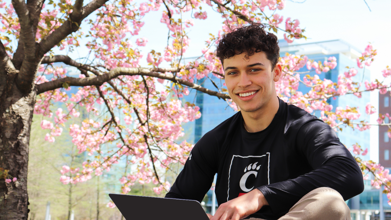 Students holding up UC on study abroad trip