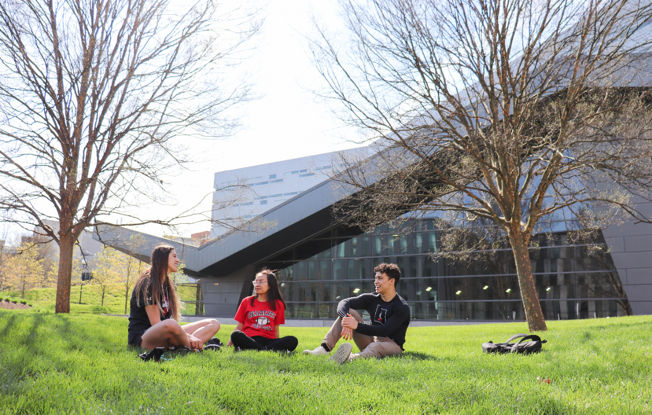 Students in grass by Recreation Center. 